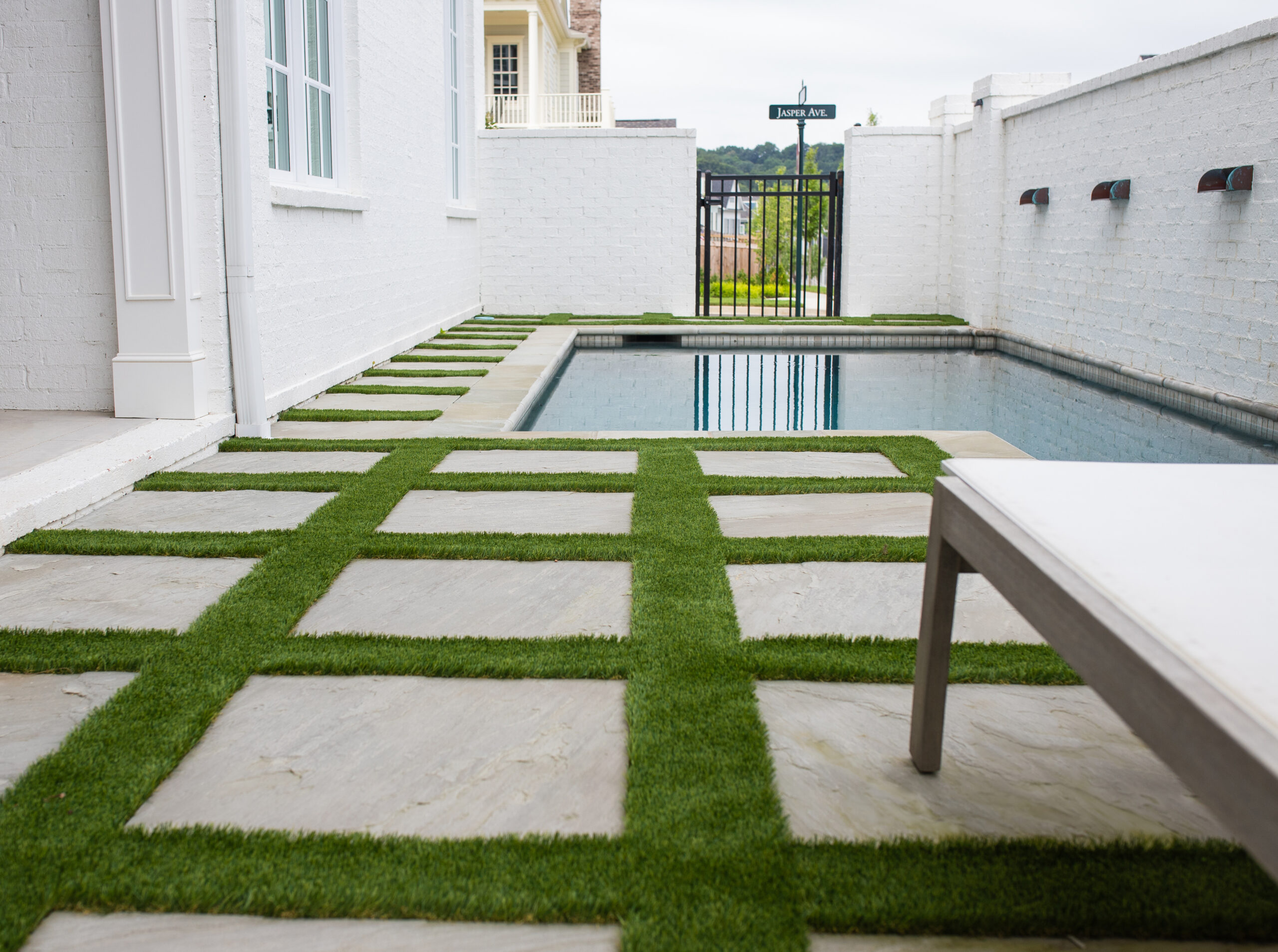 synthetic turf installed around tiles in a small yard