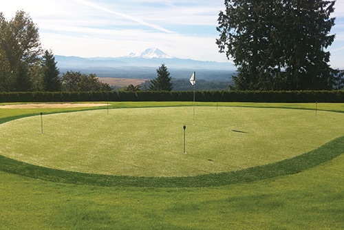 beautiful putting green with a large mountain in the background
