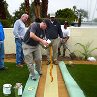 workers adding glue to the turf