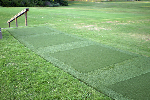 tee mats with borders lined up on grass