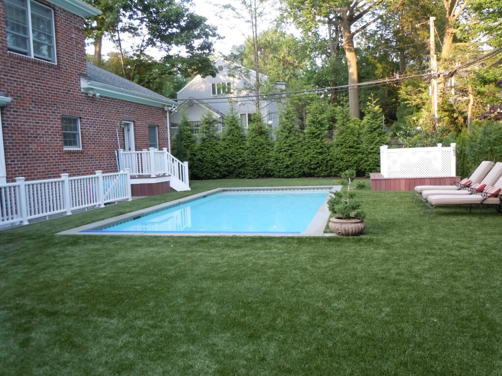 synthetic turf surrounding a pool in a backyard