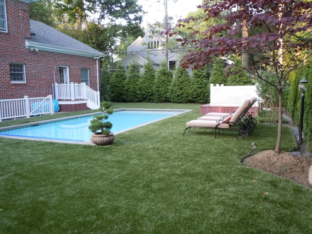 synthetic turf around a pool in a backyard